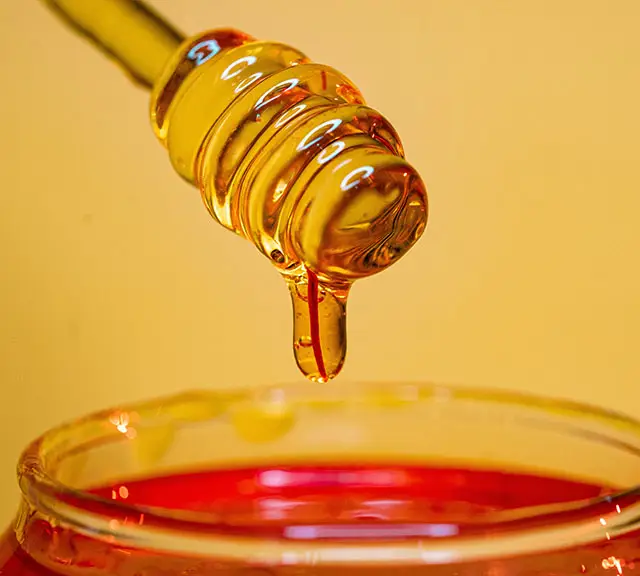 honey drizzling from a honey dipper